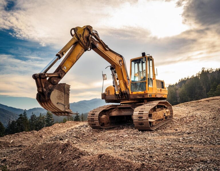 Excavadora amarilla de cadenas excavando tierra en un terreno montañoso para construcción de carreteras.