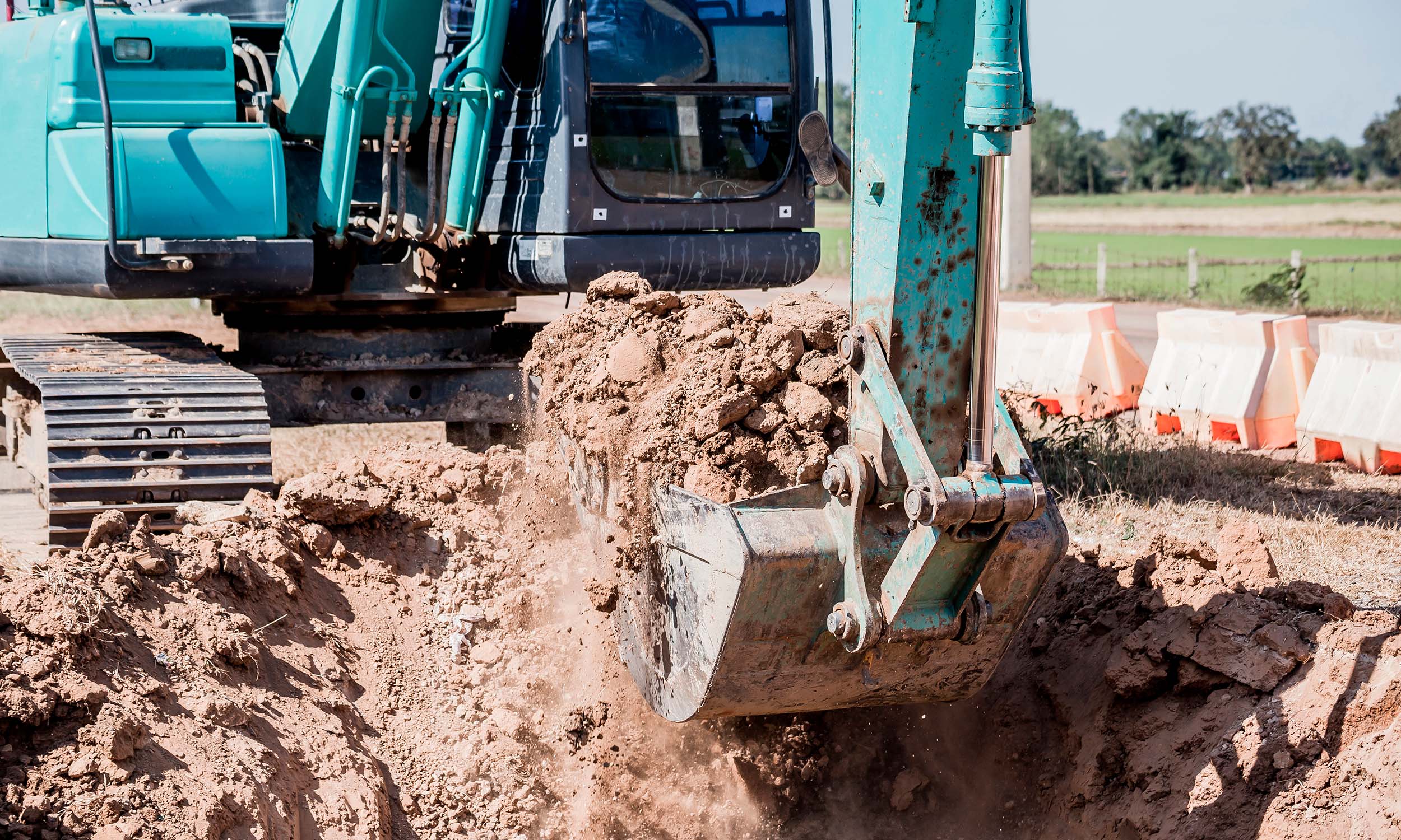 Excavator working on earthworks for the installation of modular homes.<br srcset=