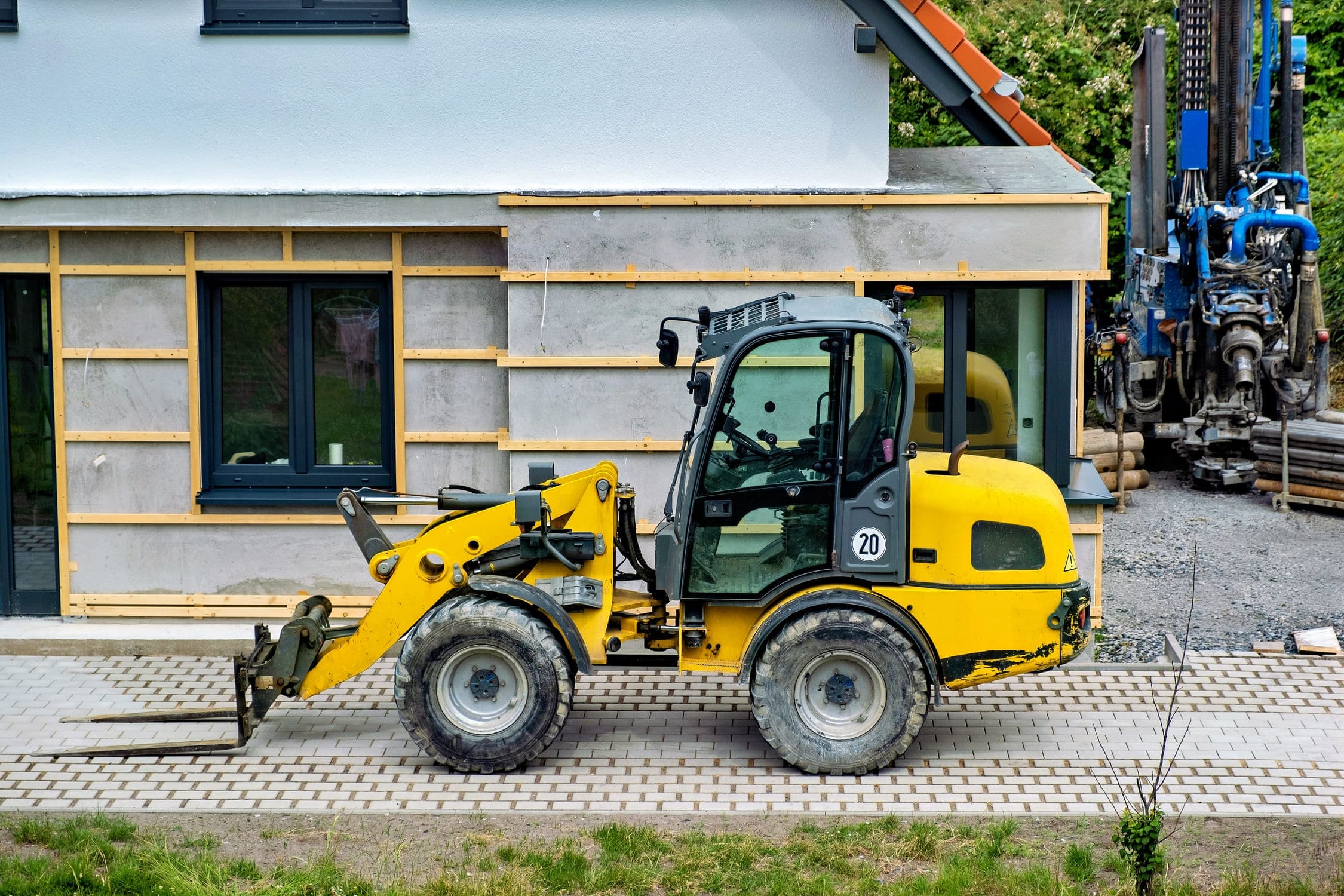 Compact skid steer loader performing material handling tasks at a construction site.