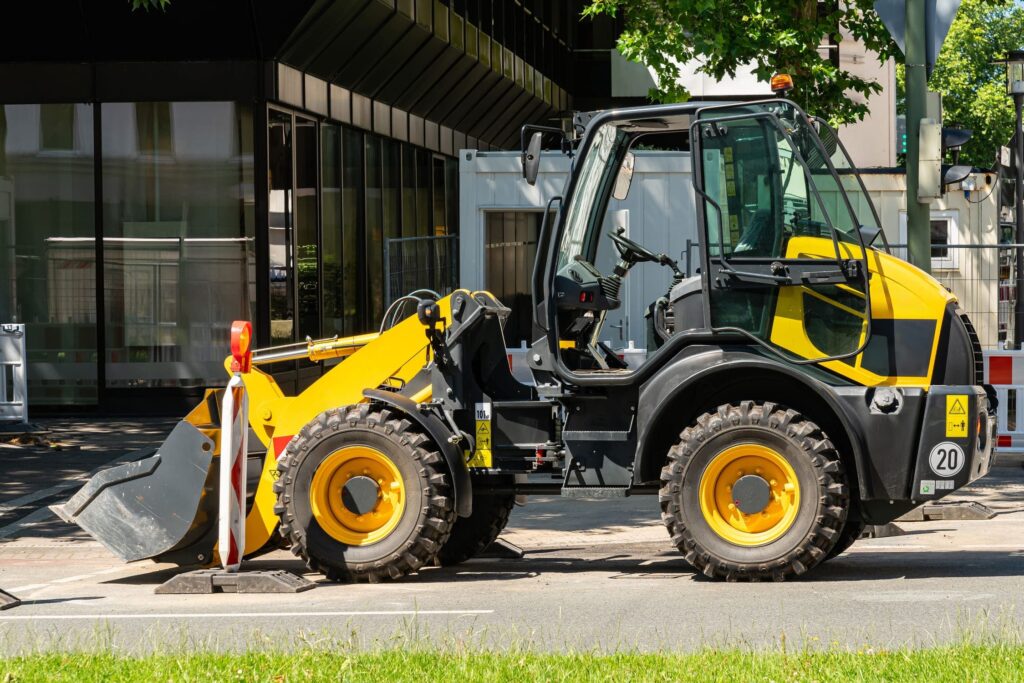 Minicargadora en obra urbana realizando carga y manipulación de materiales con pala frontal.
